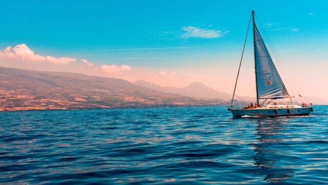 sailboat sailing on water near island