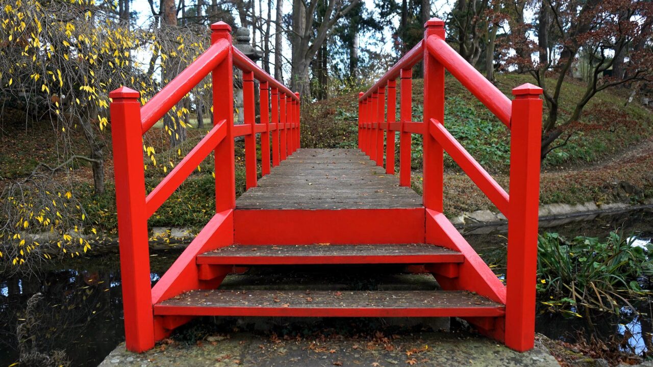 person showing red wooden bridge